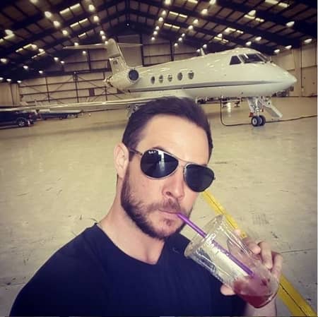 Micol's husband Ryan Merriman in front of a private jet
